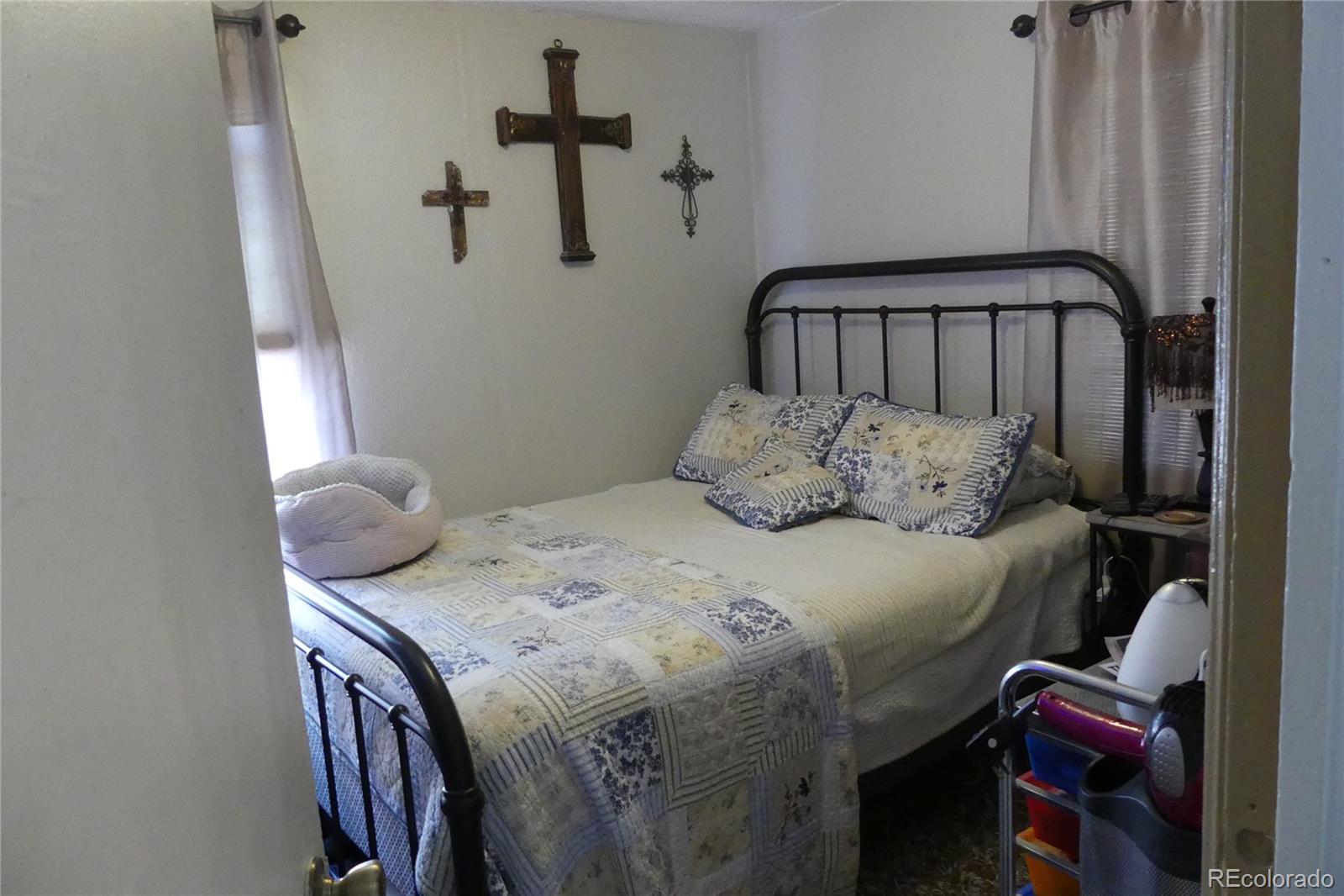 4851 Adams Street Denver, CO 80216 - Photo 29 of 30 a bedroom with a bed and wooden floor