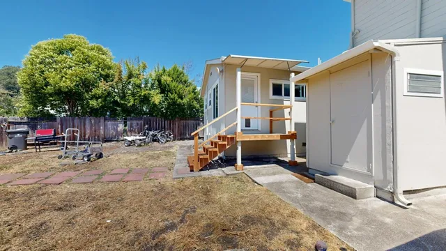 a view of a house with a patio and a yard