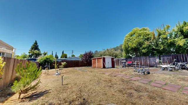 a view of a backyard with sitting area and tree
