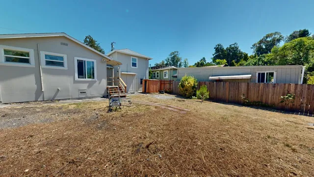 a backyard of a house with table and chairs