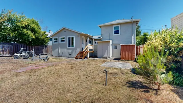 a view of a house with backyard and sitting area