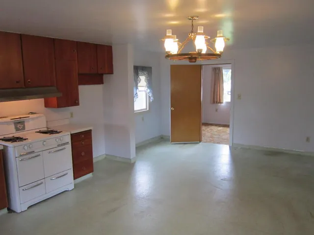 a kitchen with stainless steel appliances granite countertop a stove a sink dishwasher and a refrigerator with wooden floor