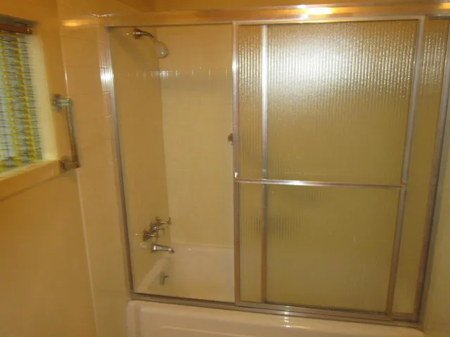 a bathroom with a glass shower door