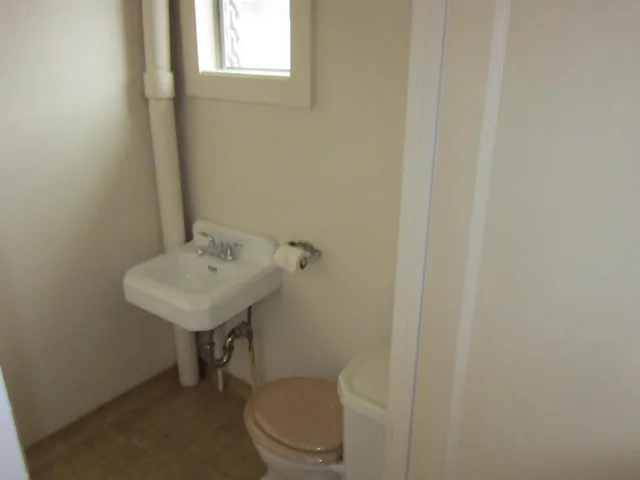 a bathroom with a toilet a sink and a window