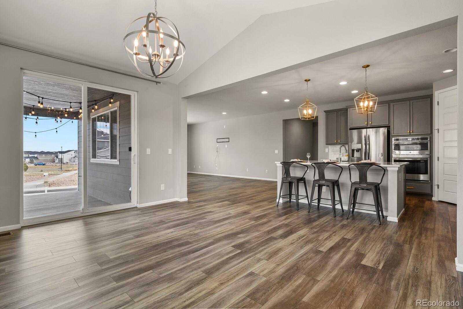 5723 Berry Ridge Wy. Castle Rock, CO 80104 - Photo 12 of 48 a view of a dining room with furniture a chandelier and wooden floor