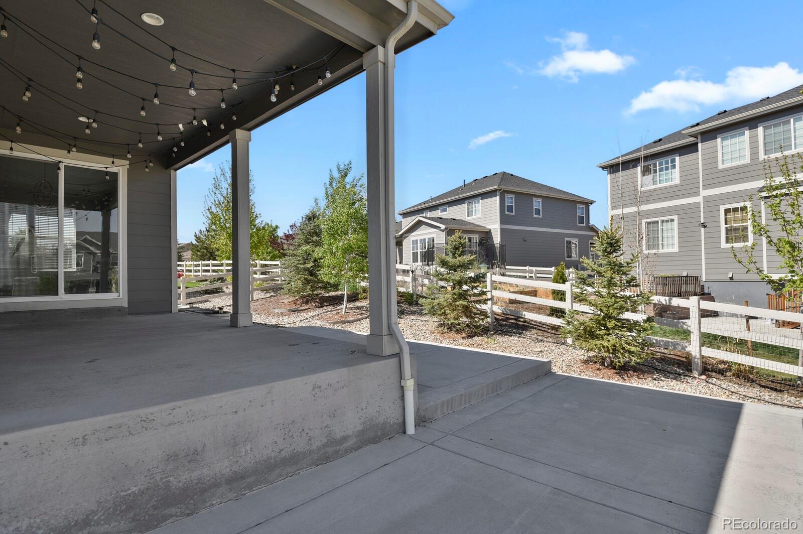 5723 Berry Ridge Wy. Castle Rock, CO 80104 - Photo 46 of 48 a porch with a table and chairs and potted plants