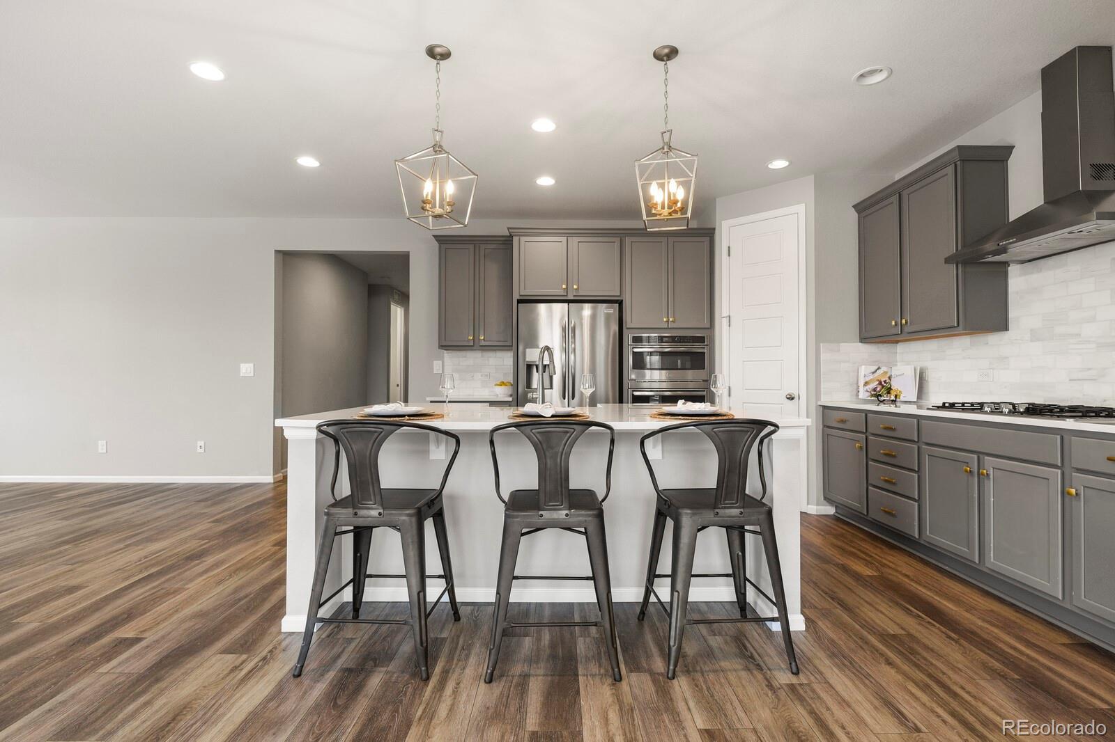 5723 Berry Ridge Wy. Castle Rock, CO 80104 - Photo 10 of 48 a kitchen with granite countertop wooden floor cabinets dining table and chairs