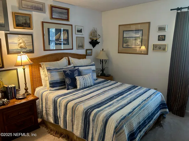 a bedroom with bed painting on the wall and a window