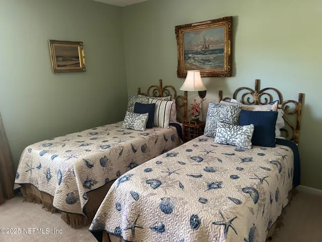 a bedroom with three beds and a painting on the wall