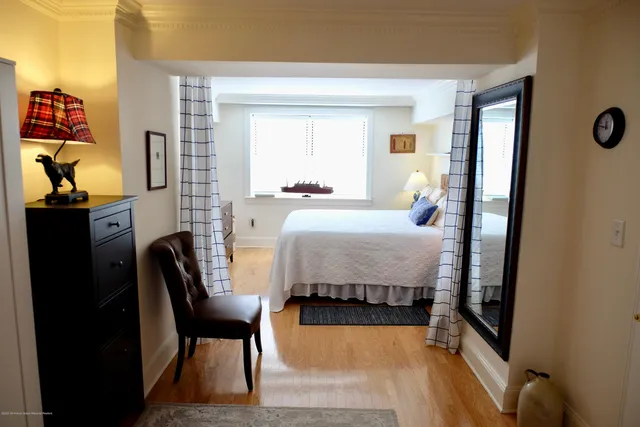 a bedroom with a bed chair and dresser