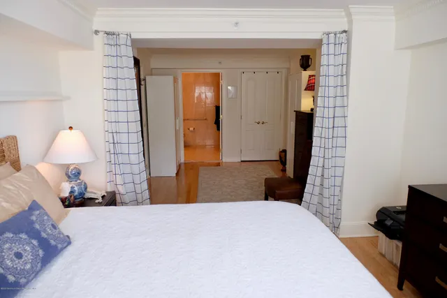 a bedroom with a bed and a lamp on dresser