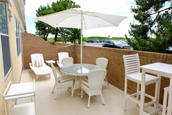 a view of a patio with table and chairs under an umbrella