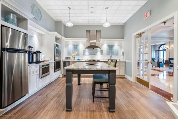 a kitchen with granite countertop a table chairs stainless steel appliances and wooden floor