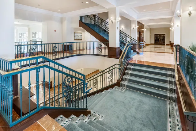 a view of staircase with white walls and a chandelier