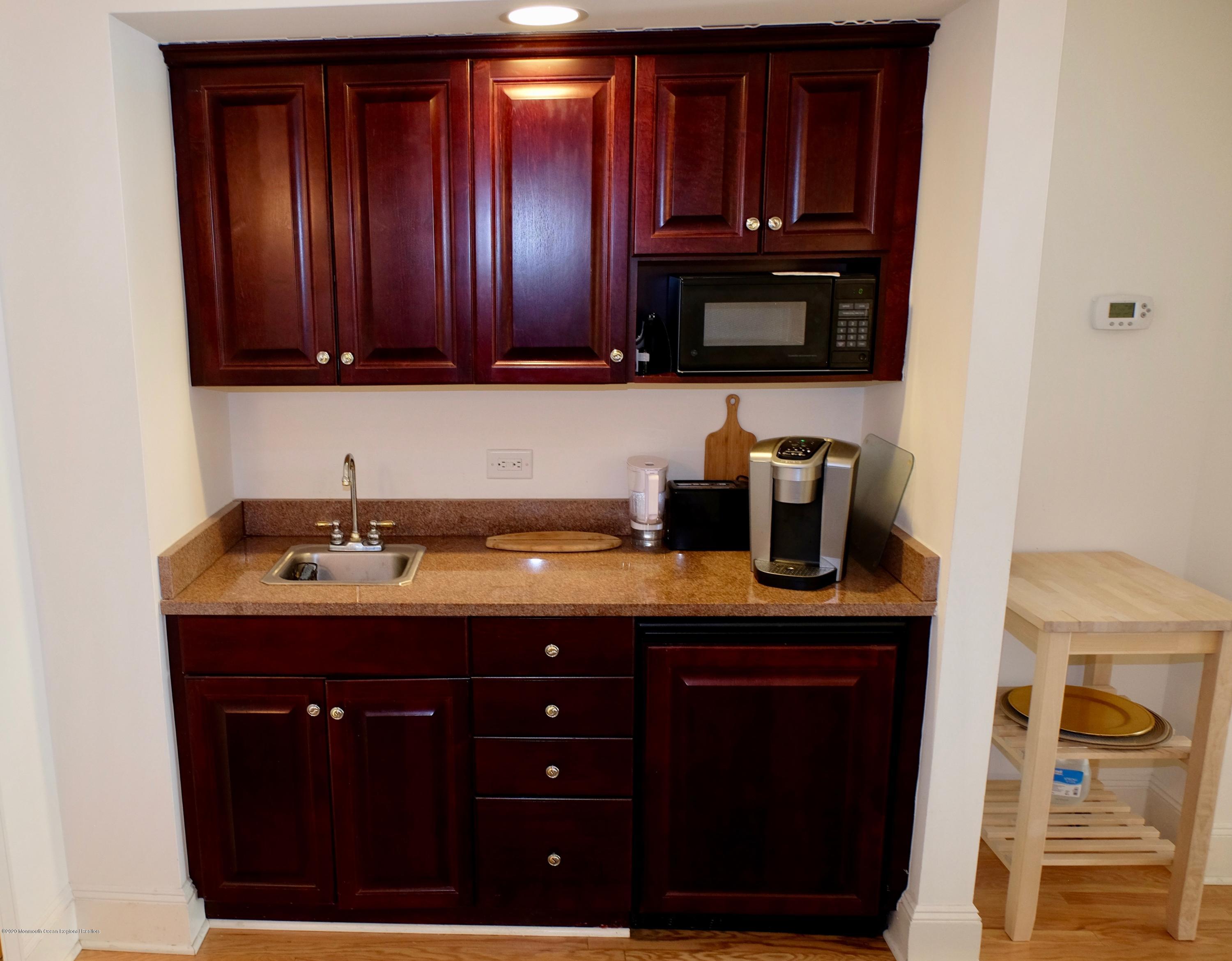 700 Ocean Avenue, Unit G1 Spring Lake, NJ 07762 - Photo 9 of 42 a kitchen with granite countertop wood cabinets and a sink