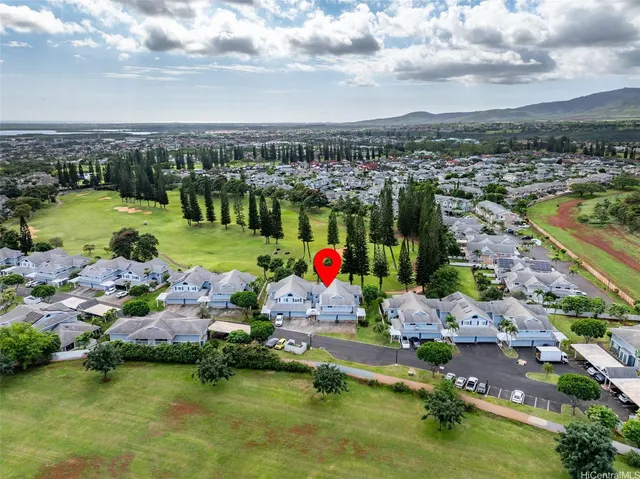 an aerial view of a houses with a garden and lake view