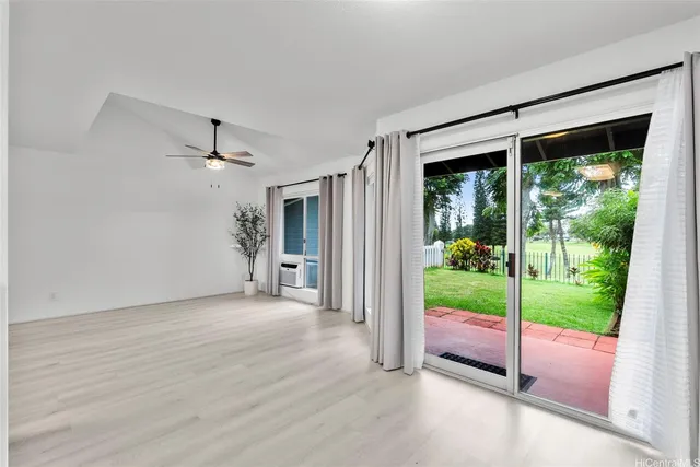 a view of an empty room with a floor to ceiling window and wooden floor
