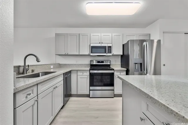 a kitchen with stainless steel appliances granite countertop a sink stove and refrigerator