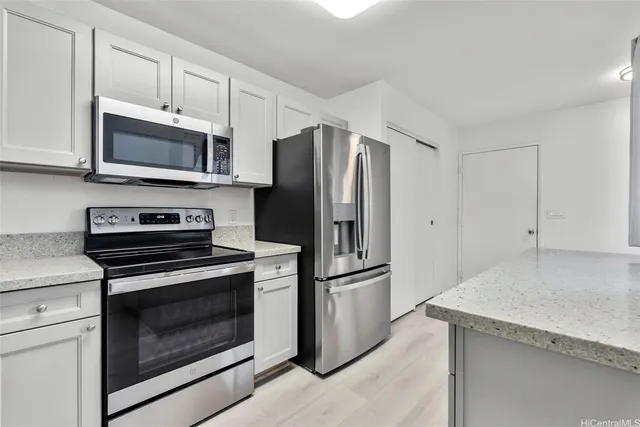 a kitchen with cabinets stainless steel appliances and a counter space