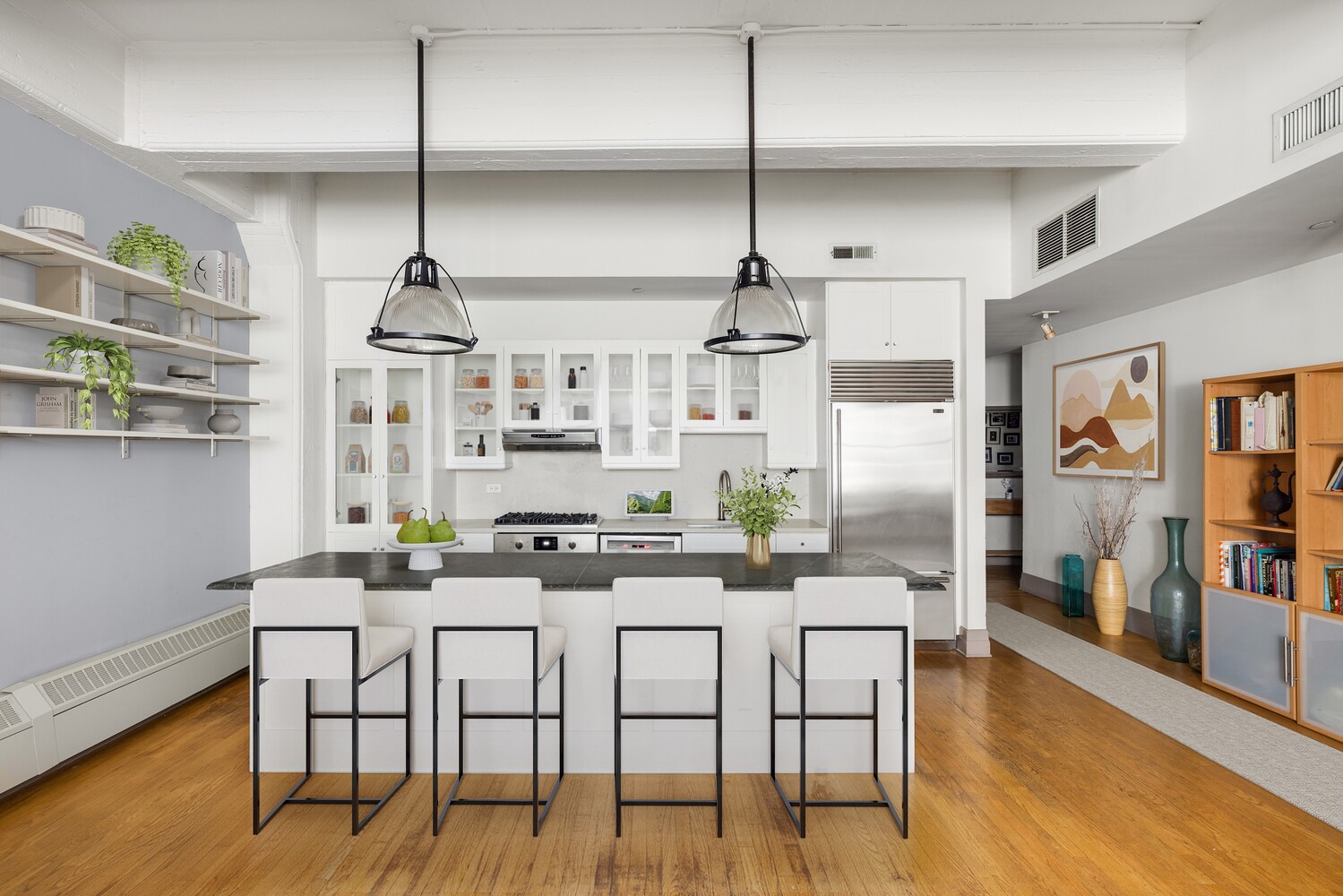 30 Main Street, Unit 3F Brooklyn, NY 11201 - Photo 2 of 12 a kitchen with stainless steel appliances kitchen island granite countertop a table chairs in it and wooden floors