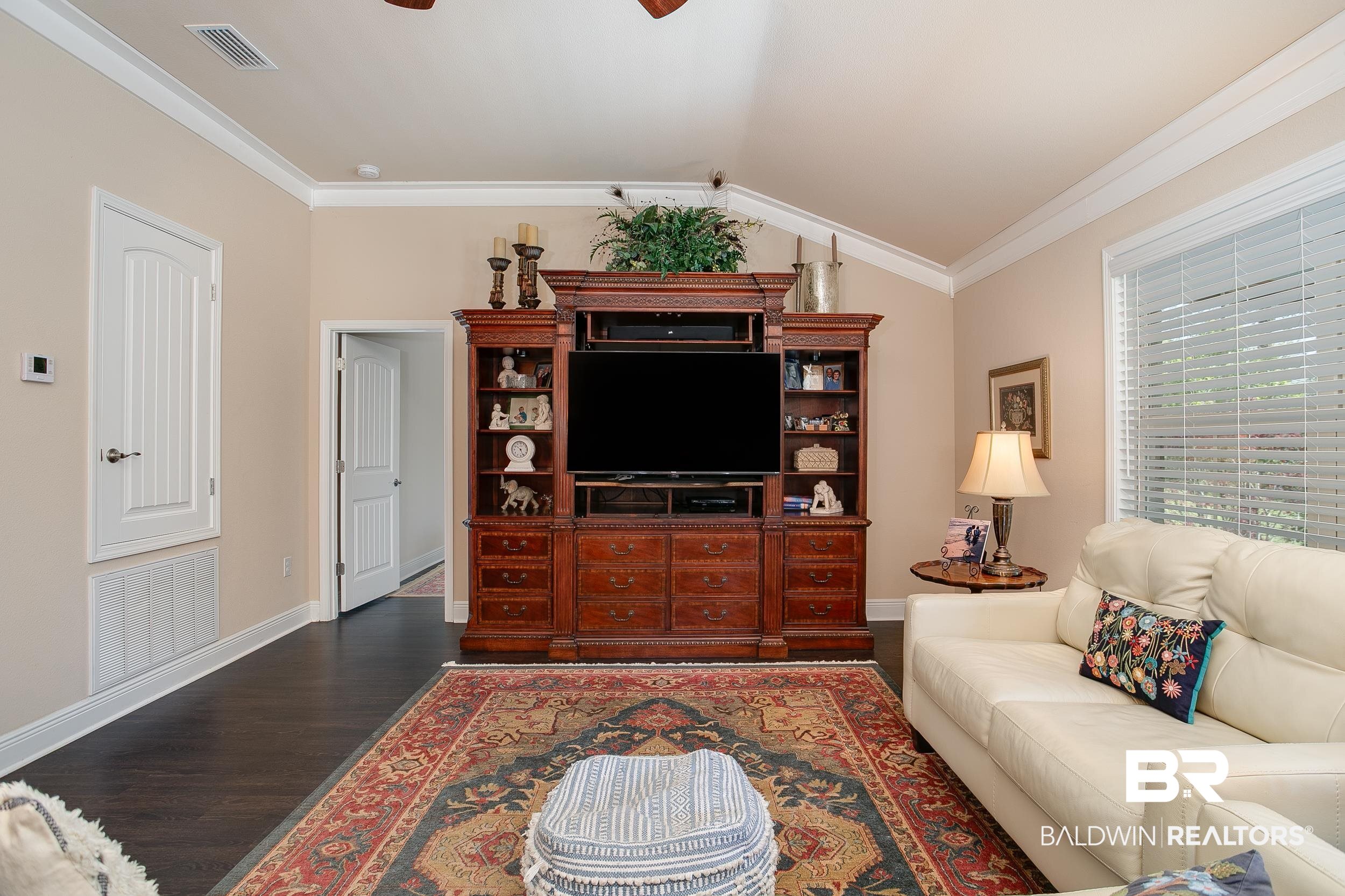 13154 Vincent Court Foley, AL 36535 - Photo 11 of 41 Living room with vaulted ceiling, ornamental molding, dark wood finished floors, visible vents, and a ceiling fan