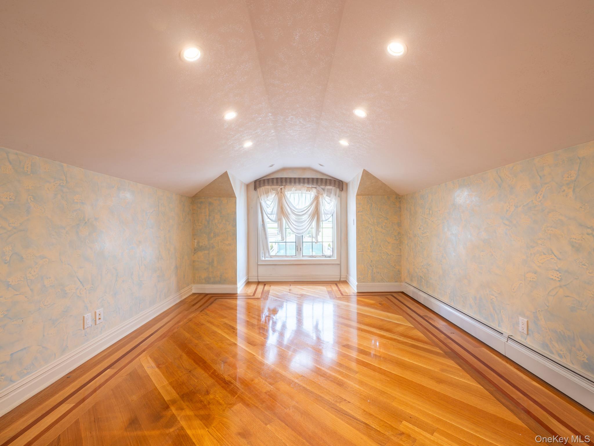 179-15 80th Road Queens, NY 11366 - Photo 23 of 35 an empty room with wooden floor and windows