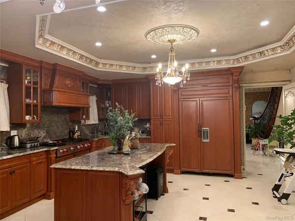 a kitchen with a chandelier a sink and cabinets
