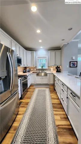 a kitchen that has a sink cabinets counter space and stainless steel appliances