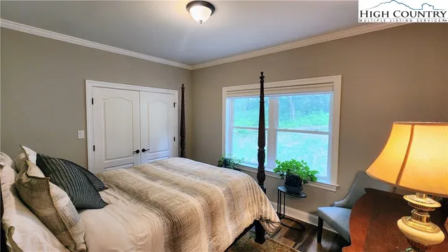 a bedroom with a bed and a flat tv screen on the dresser