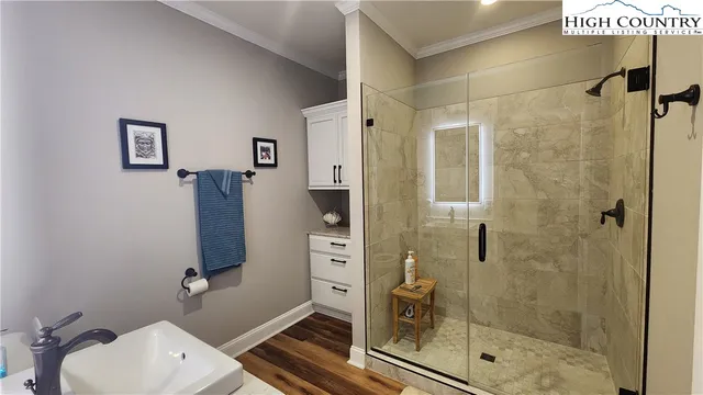 a bathroom with a shower a sink and a mirror