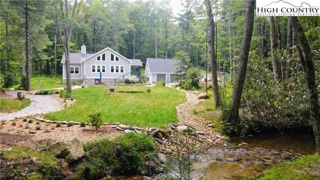 a view of a house with a yard and a fountain
