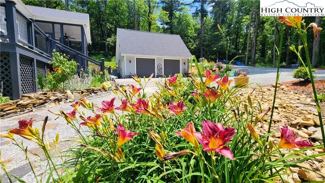 a front view of a house with a yard and potted plants