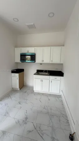 a kitchen with stainless steel appliances a stove a microwave a sink and cabinets
