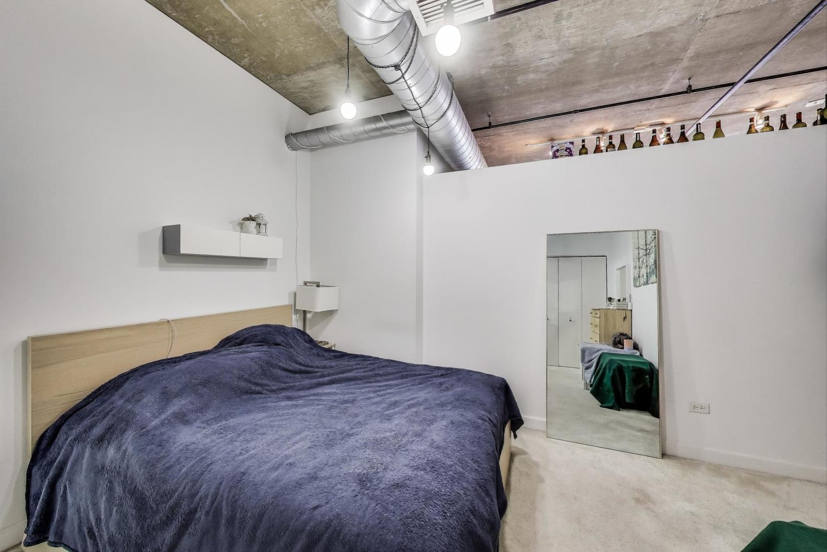 111 South Morgan Street, Unit 510 Chicago, IL 60607 - Photo 26 of 38 a bedroom with a bed and a chandelier