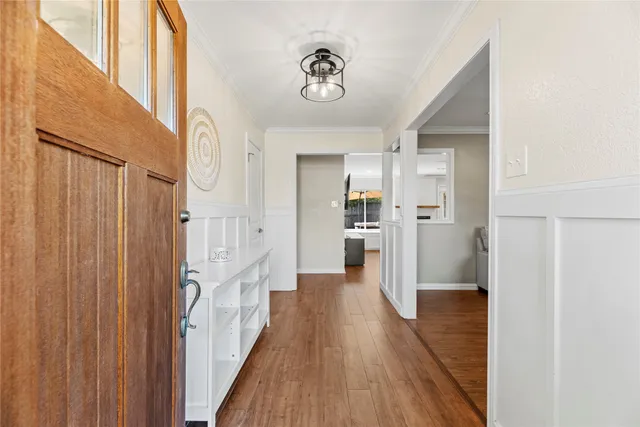 a view of a hallway with wooden floor and staircase