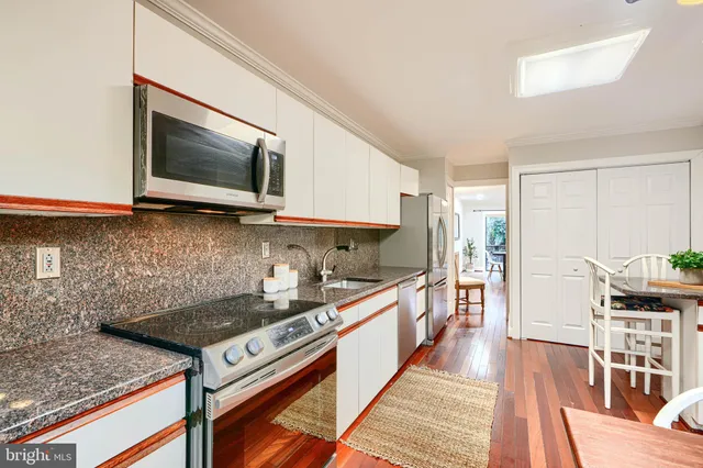 a kitchen with stainless steel appliances kitchen island granite countertop a stove a sink and a microwave