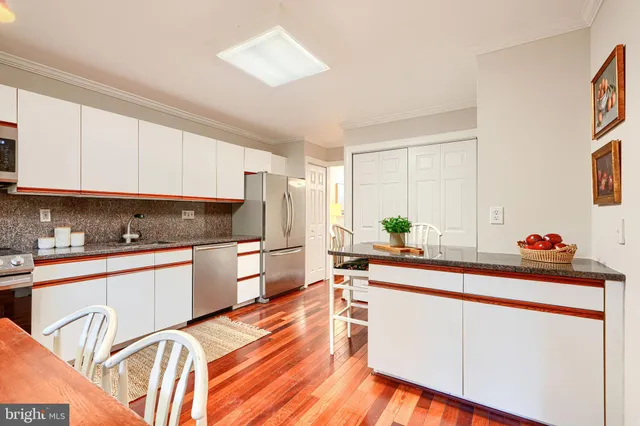 a kitchen with stainless steel appliances a sink cabinets and wooden floor