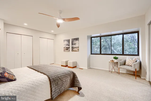 a bedroom with a bed couches and painting on the wall