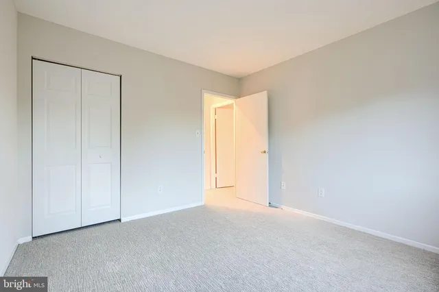 a view of an empty room and a chandelier fan