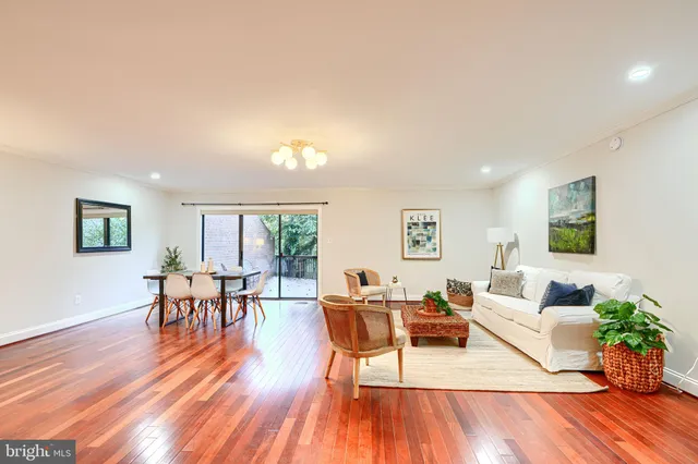a living room with furniture a wooden floor and a window