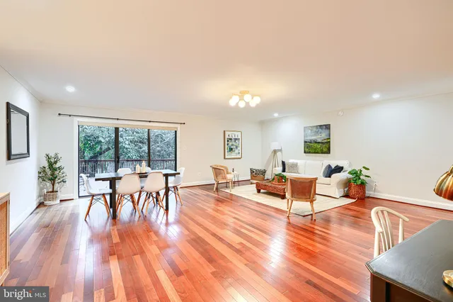a living room with furniture a wooden floor and next to a window
