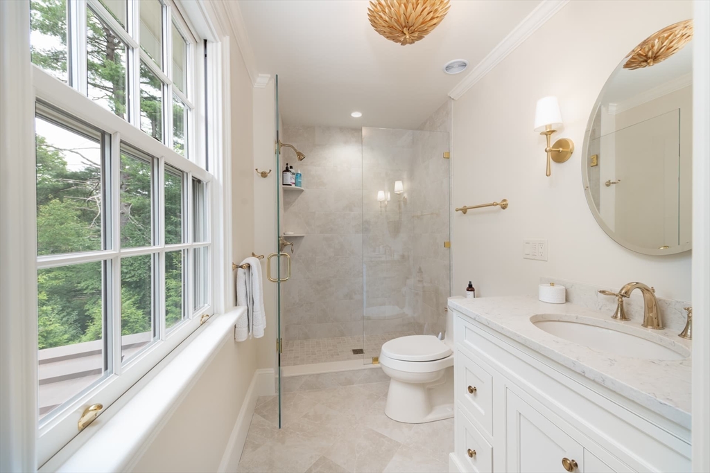 46 Concord Road Weston, MA 02493 - Photo 28 of 42 a bathroom with a granite countertop sink a toilet and a large mirror next to a window