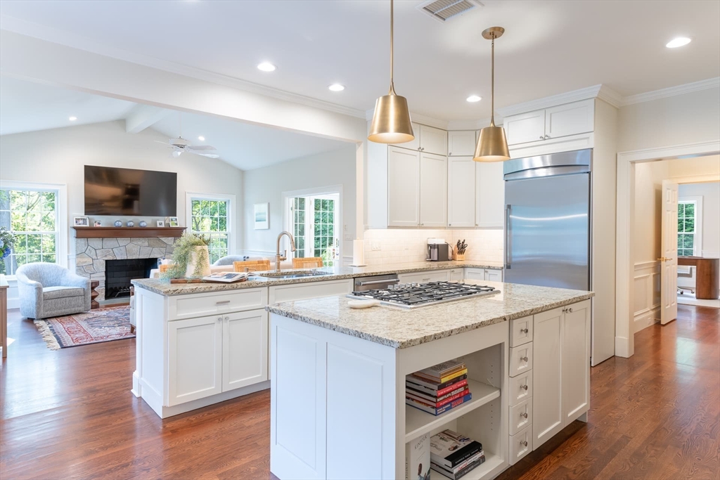 46 Concord Road Weston, MA 02493 - Photo 10 of 42 a open kitchen with stainless steel appliances granite countertop a stove top oven a sink dishwasher a dining table and chairs with wooden floor