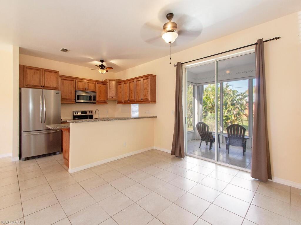18254 Hepatica Road Fort Myers, FL 33967 - Photo 4 of 12 a kitchen with kitchen island a counter top space appliances and a dining table