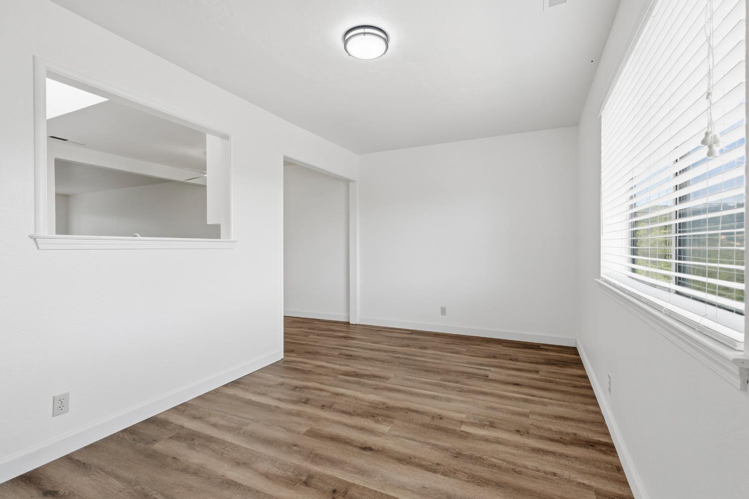 91 Summit Avenue Sonora, CA 95370 - Photo 22 of 53 a view of an empty room with wooden floor and a window