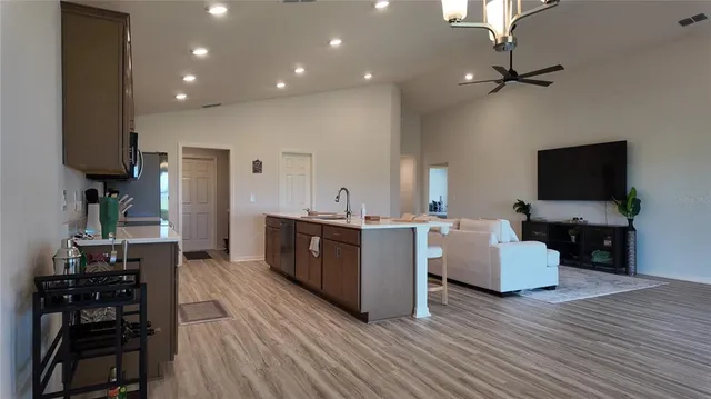 a living room with furniture a flat screen tv and kitchen view