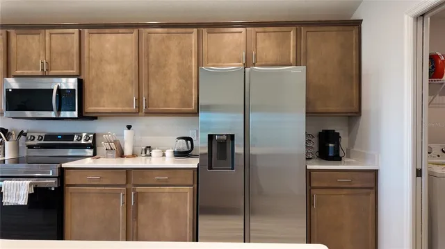 a kitchen with a refrigerator stove and cabinets