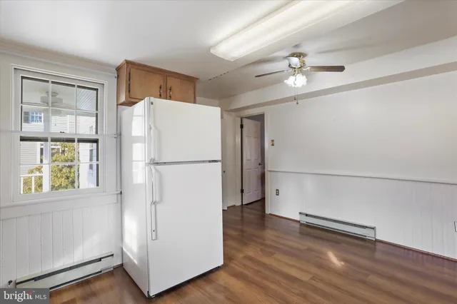 a view of empty room with wooden floor and window