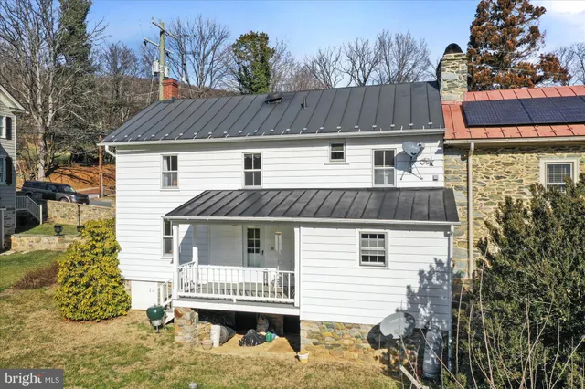 a view of a house with a yard and wooden fence