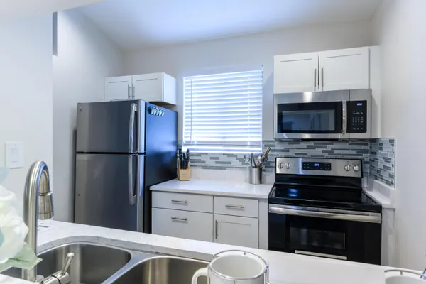 a kitchen with stainless steel appliances a stove microwave and refrigerator